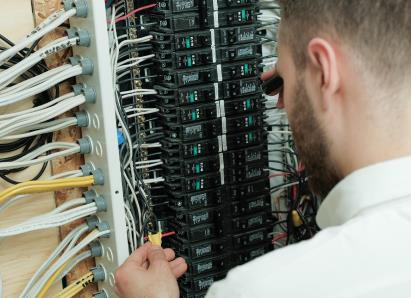 Haven Home electrical technician examining wiring connections inside a circuit breaker panel for a residential service check. Haven Home electrical technician examining wiring connections inside a circuit breaker panel for a residential service check.