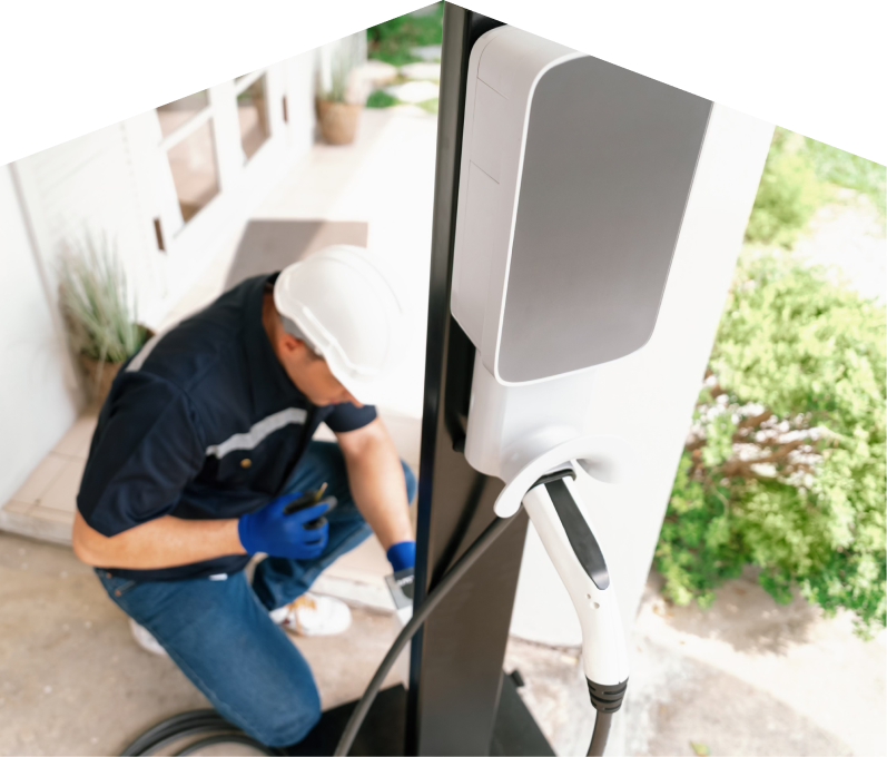 Home service electrician from Haven Home installing an EV charger fixed to a vertical post near a residential entryway. Home service electrician from Haven Home installing an EV charger fixed to a vertical post near a residential entryway.