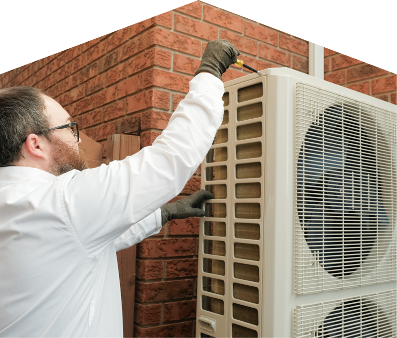 Haven Home HVAC specialist using a screwdriver to complete a heat pump installation beside a brick wall. Haven Home HVAC specialist using a screwdriver to complete a heat pump installation beside a brick wall.