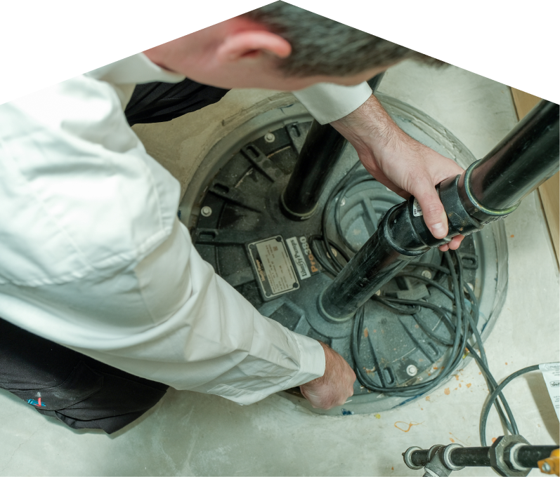 Haven Home sump pump specialist secures discharge piping on a sealed basin during a sump pump installation in a basement utility area. Haven Home sump pump specialist secures discharge piping on a sealed basin during a sump pump installation in a basement utility area.