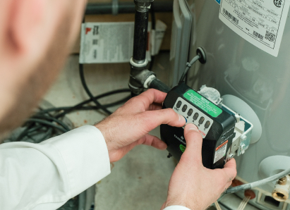 A Haven Home technician adjusts the control module on a residential water heater, verifying proper operating settings. A Haven Home technician adjusts the control module on a residential water heater, verifying proper operating settings.